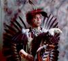 Primary view of [An Indigenous American in traditional black and red powwow clothing, 4]
