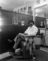 Photograph: [A barber sitting in a barbers chair]