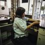 Photograph: [A woman working in a parking booth]