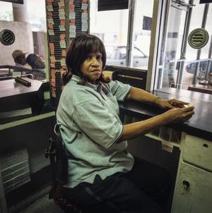 Primary view of object titled '[A woman working in a parking booth as the attendant]'.