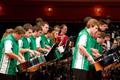 Photograph: [Rows of percussionists in green shirts performing onstage, 6]