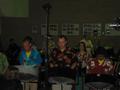 Photograph: [Rows of drummers wearing brightly patterned shirts]
