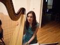Photograph: [A girl in a light blue dress sitting behind a harp]