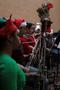 Primary view of [A row of people playing bassoons adorned with tinsel, 1]