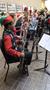 Primary view of [A row of people playing bassoons adorned with tinsel, 3]
