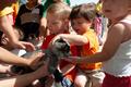 Photograph: [Children petting baby goat]
