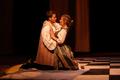 Photograph: [A man and a woman kneeling and embracing during a stage production]