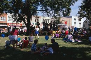 Primary view of object titled '[People sitting on the lawn of the old Denton County Courthouse, on County Seat Saturday]'.