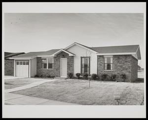 Primary view of object titled '[Exterior of a house with a small garage]'.