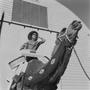 Photograph: [A model riding a camel with Neiman-Marcus boxes]