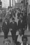 Photograph: [Three men walking down a crowded street, 2]