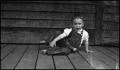 Photograph: [Toddler sitting on a porch]