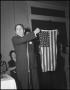 Photograph: [Man holding up an American flag, 1]