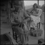 Photograph: [Photograph of a man and a girl working on the porch]