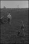 Photograph: [Photograph of a young boy and a farmer in a field]