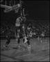 Photograph: [Basketball Player Tossing Ball Towards The Hoop]