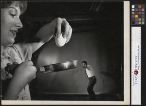 Primary view of object titled '[John Milligan prepares to scramble and egg with his Slingshot]'.