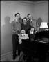 Photograph: [Family standing at their piano, 2]