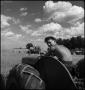 Photograph: [Young man driving a tractor shirtless]