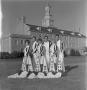 Photograph: [Six cheerleaders in front of the Hurley Administration Building]