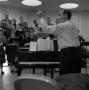 Photograph: [Richard Lamb directing the chapel choir during rehearsal]