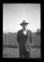 Primary view of [Byrd Williams, Jr. standing in a backyard]