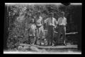 Photograph: [Irene Williams standing on a log bridge with her sons]
