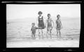 Primary view of [Irene Williams and her sons standing in water on a shoreline]