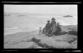 Photograph: [Byrd III, Irene, Charles, and John Williams sitting on a rocky shore]