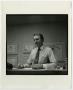 Photograph: [Photograph of a man seated at desk]