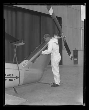 Primary view of object titled '[A Bell employee inspecting the tail of a YH-40]'.