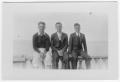 Photograph: [Two Unidentified Men Sitting on a Wall with Bob Blackshear]