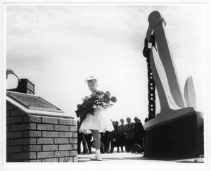 Primary view of object titled '[A young girl carrying flowers at a memorial service for victims of the 1947 Texas City Disaster]'.
