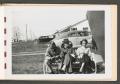 Photograph: [Trio Sitting on Bench in Yard]