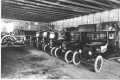 Photograph: [Interior of a car company, possibly Kiefner Motor Co., cars lined up]