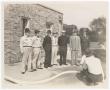 Photograph: [Seven Men Standing in Front of Brick Building #2]