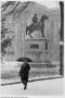 Photograph: [Man walking in snow before Ranger statue at Texas State Capitol buil…