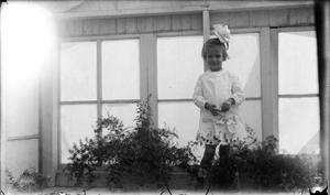 Primary view of object titled '[Child Standing in Front of Windows]'.