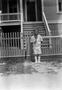 Photograph: [Child Standing in Front of a Fence]