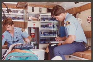 Primary view of object titled '[Two Paramedics with Patient in an Ambulance]'.