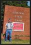 Photograph: [Photograph of Bill Martin with the Central State Farm Sign]