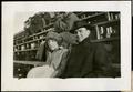 Photograph: [Man and woman on wooden bleachers on Simmons College campus]