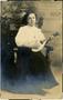Text: [Photograph of Nora playing a mandolin:  Postcard addressed to T. N. …
