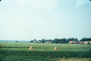 Primary view of object titled '[Rural Poland Fields and Hay Piles]'.