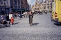 Photograph: [Woman riding a bike whie holding a child]