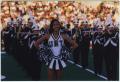 Photograph: [North Texas dancer and marching band at 1997 Homecoming halftime sho…
