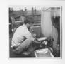 Photograph: [Cook Washes Dishes on the Evaleeta]