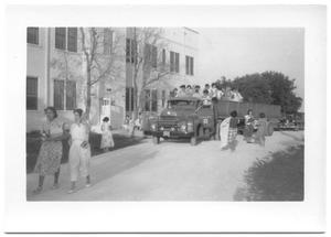 Primary view of object titled '[Truck Full of People Parked in Front of a School Building]'.