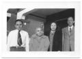 Photograph: [Four People Standing In a Brick Building]