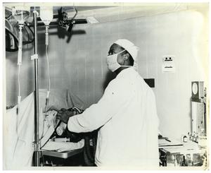 Primary view of object titled '[Dr. Herman A. Barnett Works on a Patient Before Surgery]'.